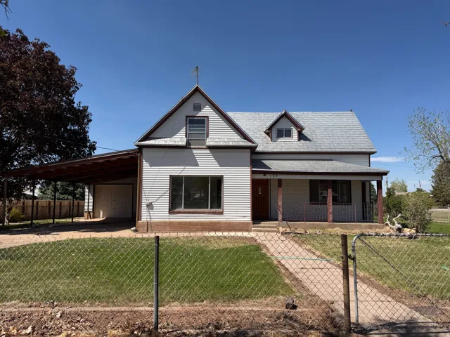 White siding exterior with a covered front porch featuring a dormer window