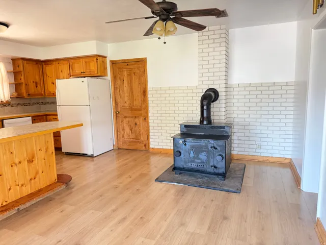 Central wood-burning stove with a black pipe, set against a white brick-finish wall