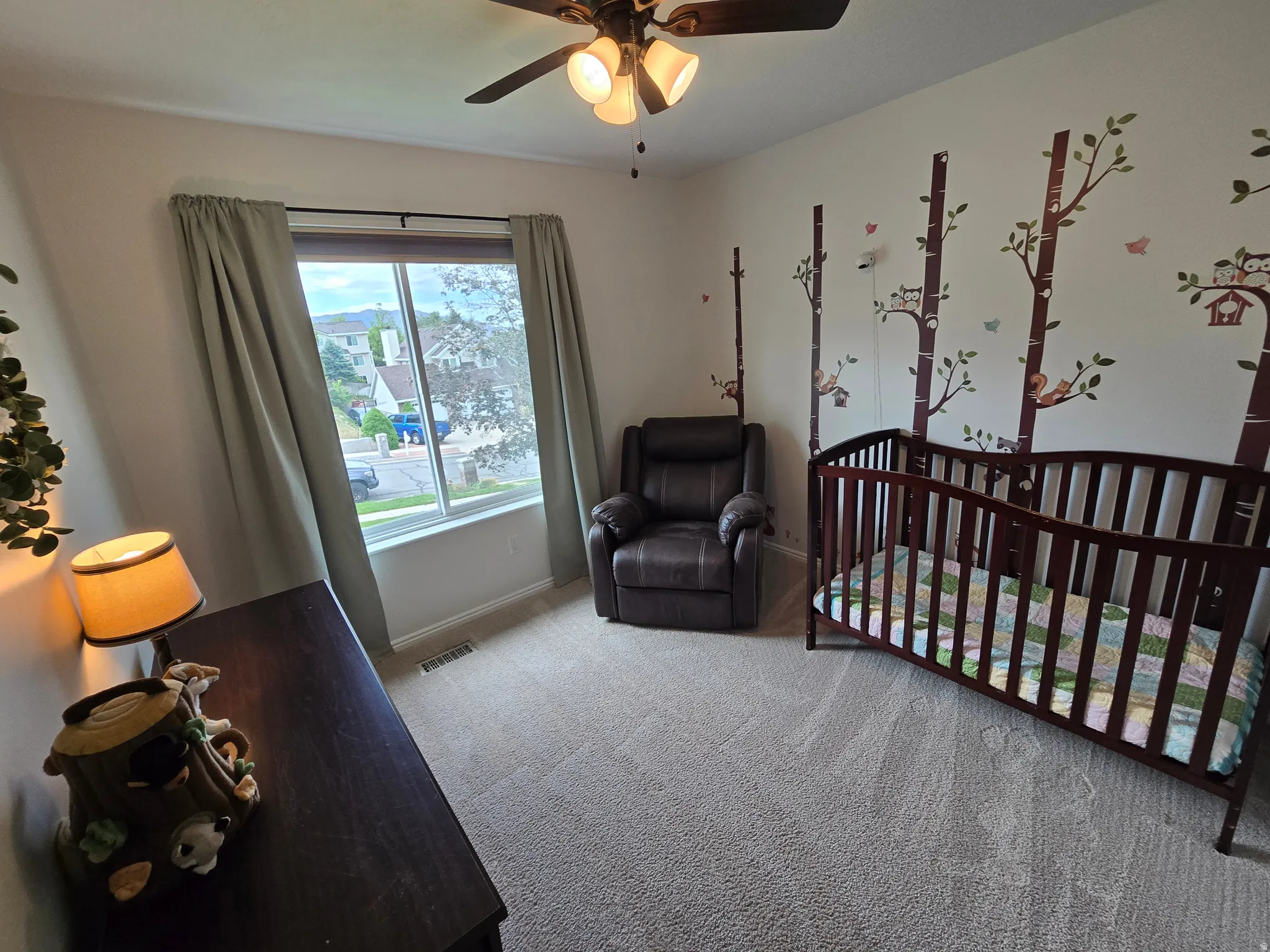 Carpeted room with a ceiling fan, a window, and wall decals