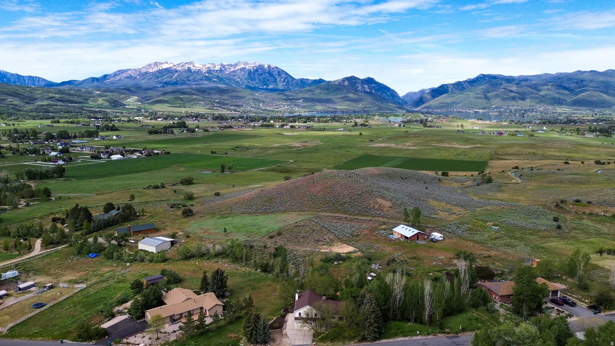 Expansive landscape featuring rolling hills and distant snow-capped mountains