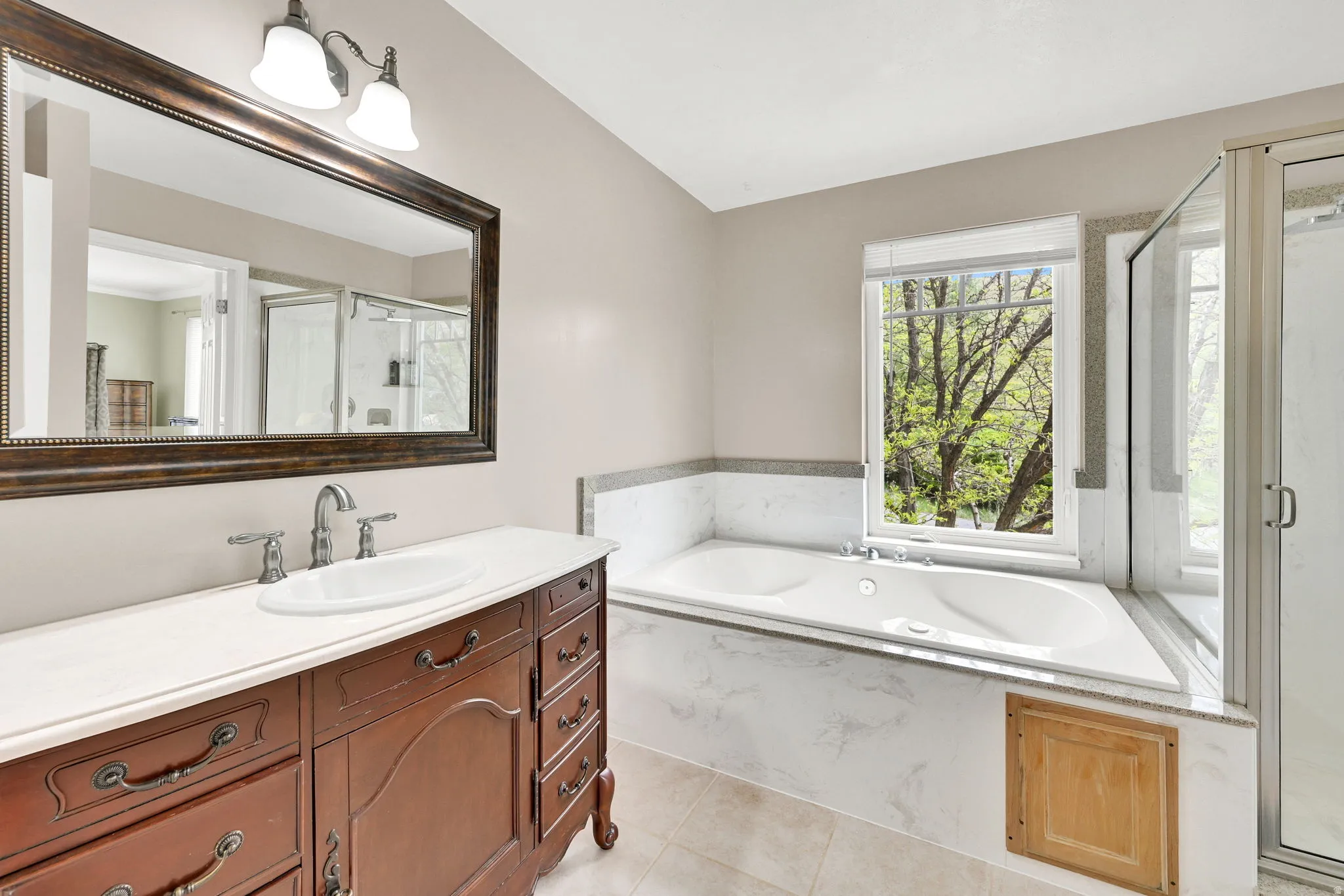 Bathroom featuring a classic wood-finish vanity with an oval undermount sink and polished chrome faucet