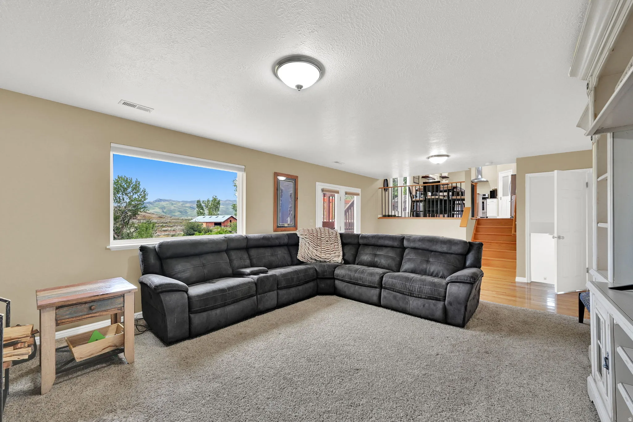 Lower-level living area featuring neutral-tone walls, recessed lighting, and carpeted flooring