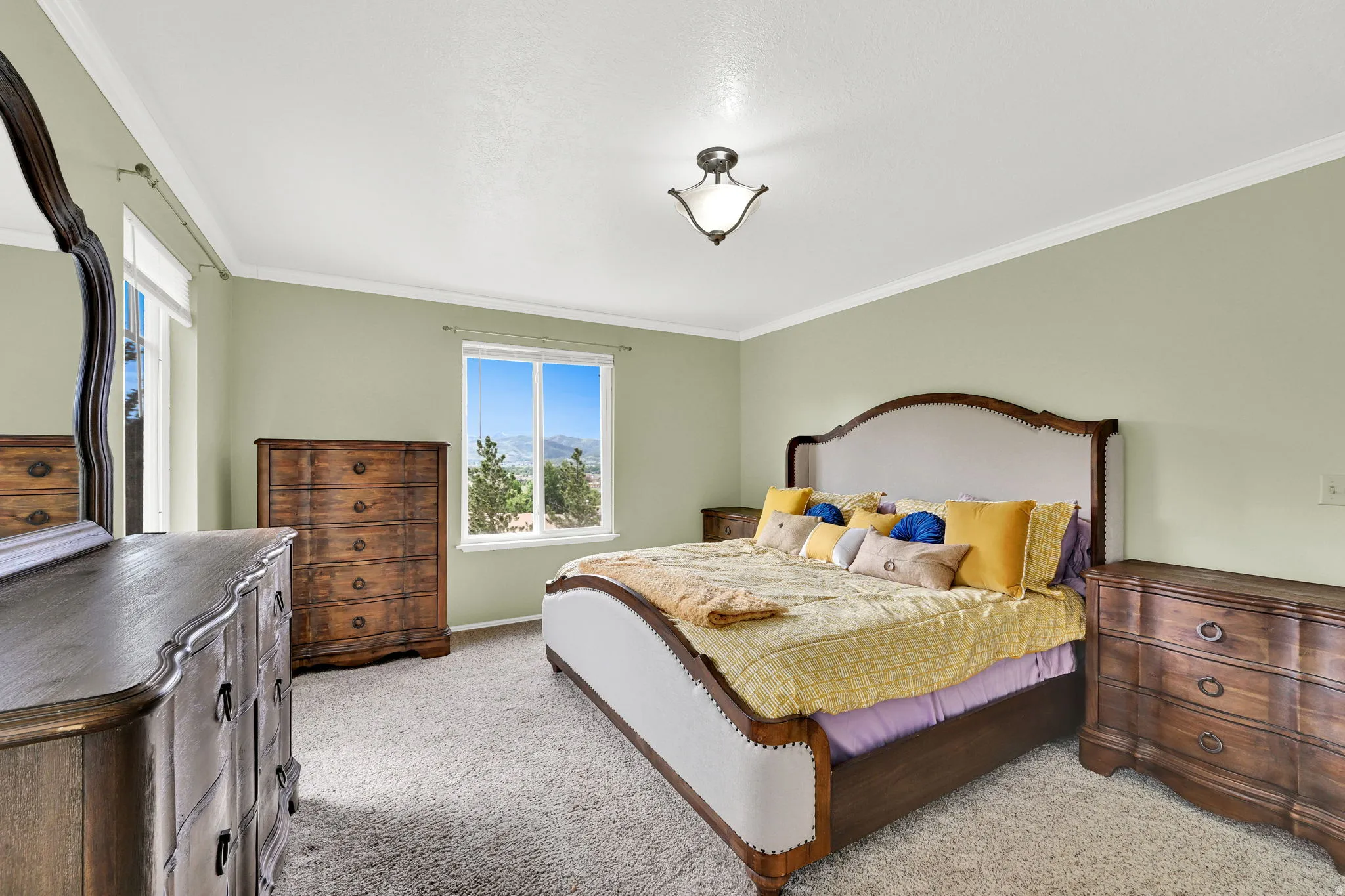 Spacious room featuring light green walls, white crown molding, and plush carpeting