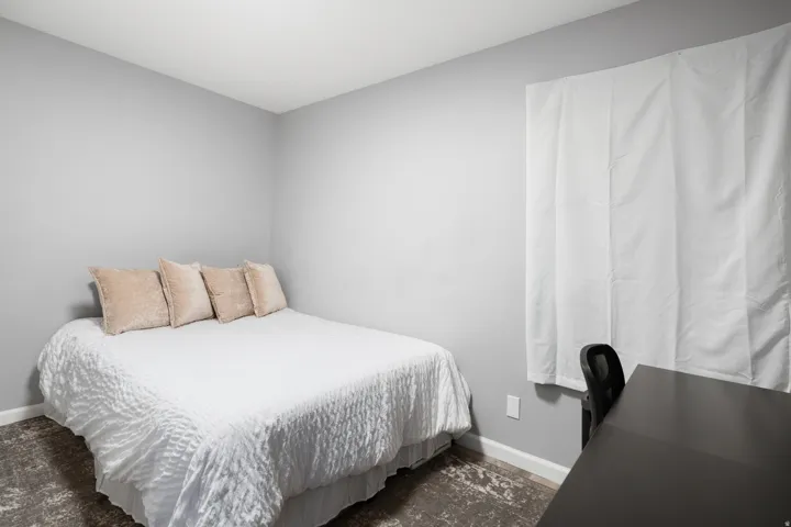 Interior room featuring light gray walls, white trim, and a window with white coverings