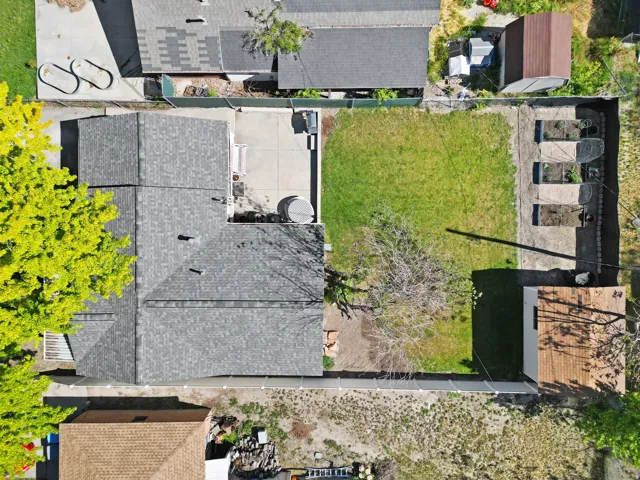 Property featuring a shingle roof, concrete patio, and a grass lawn