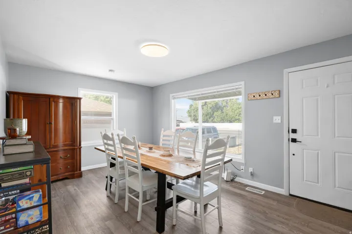 Dining area with wood-finish flooring, light gray walls, and white trim