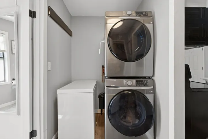 Dedicated laundry area featuring a stacked washer and dryer unit