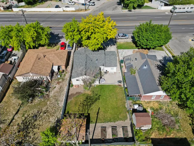 Rear property featuring a substantial lawn area, a paved patio, and a detached shed
