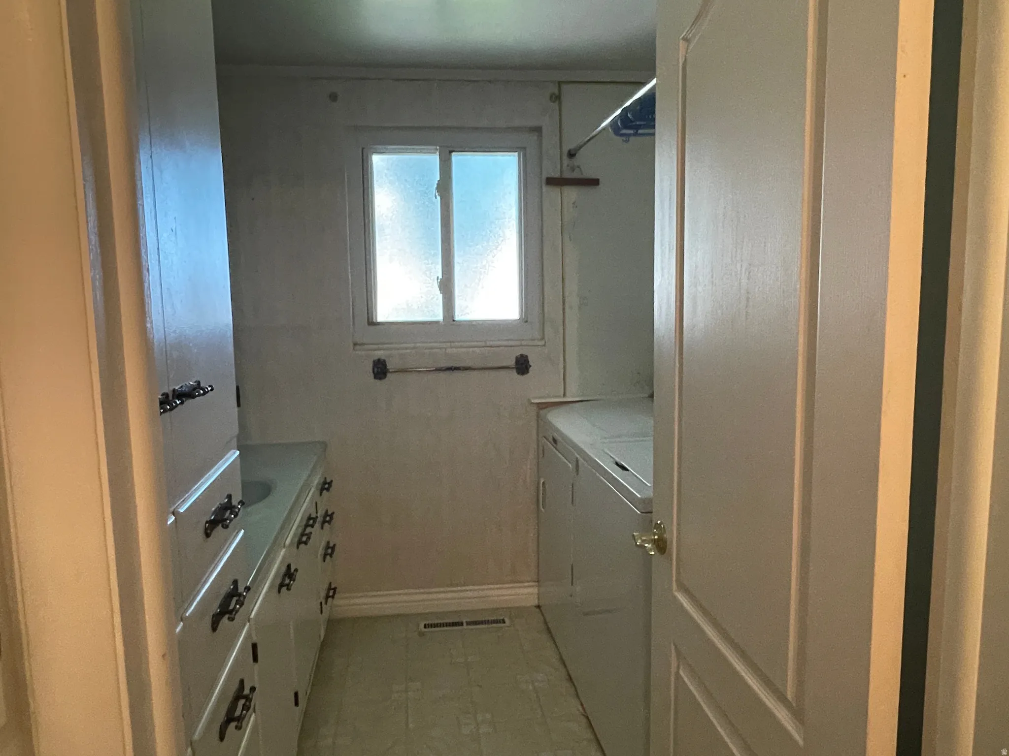 Utility room featuring a window, built-in cabinetry, and tile flooring