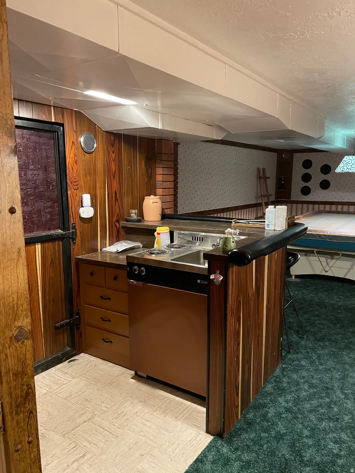 Compact kitchenette featuring a dual-burner cooktop, integrated sink, and under-counter refridgerator