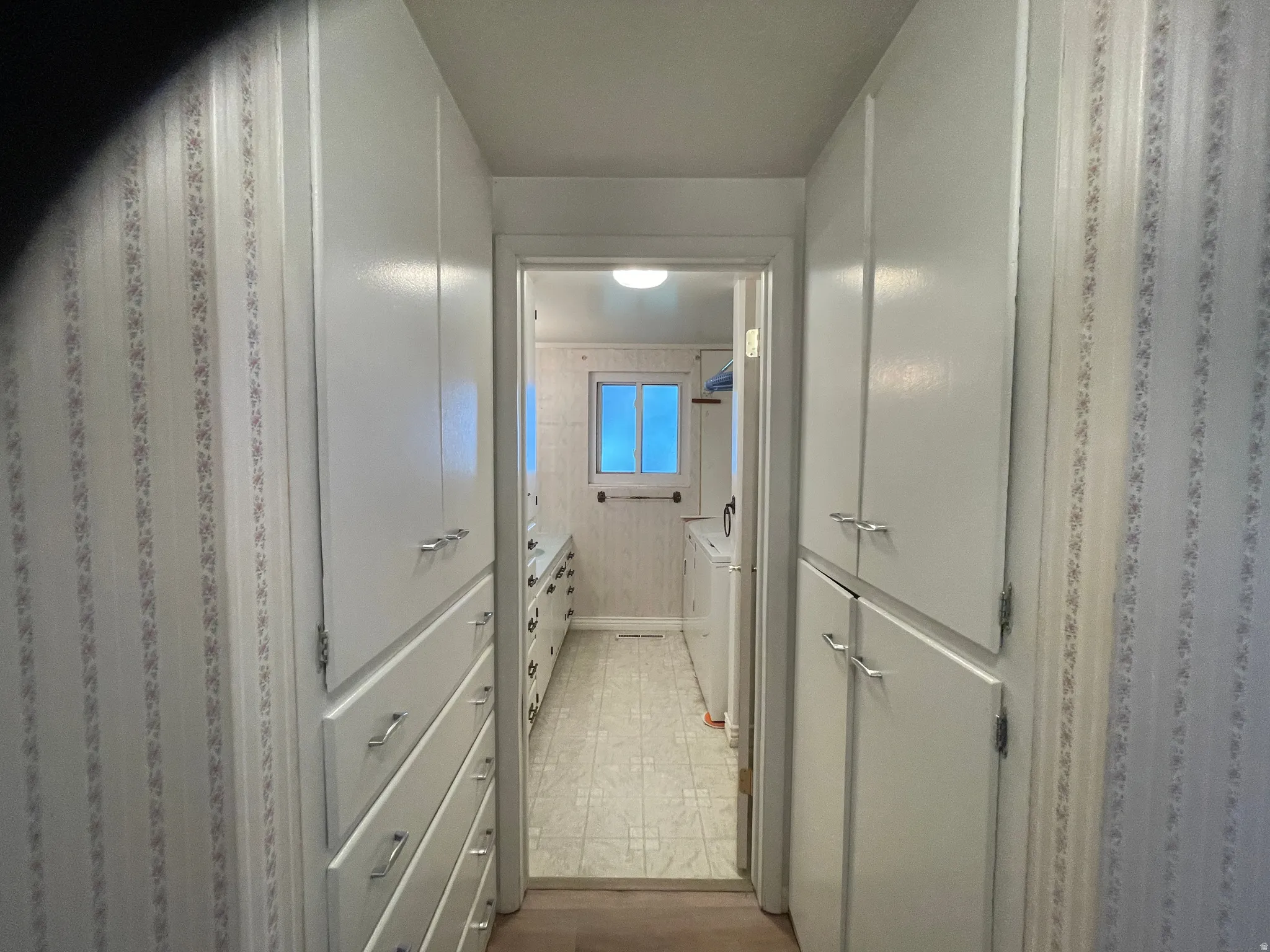 Hallway entry to half bath and laundry with  extensive built-in cabinetry and drawers