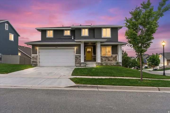 Contemporary two-story residence featuring a gray exterior with stone veneer accents