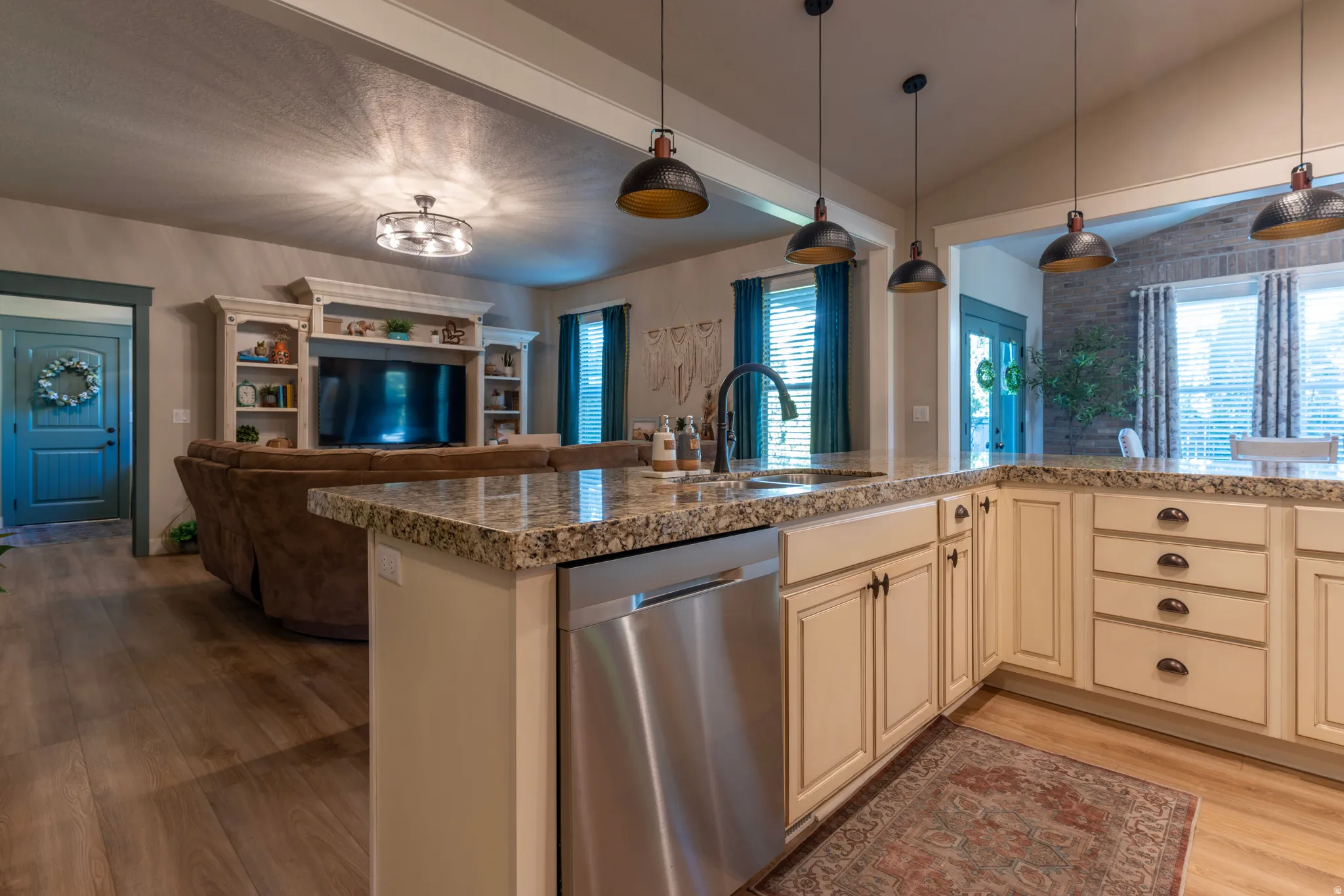 Kitchen island with granite countertop, integrated sink, and stainless steel dishwasher