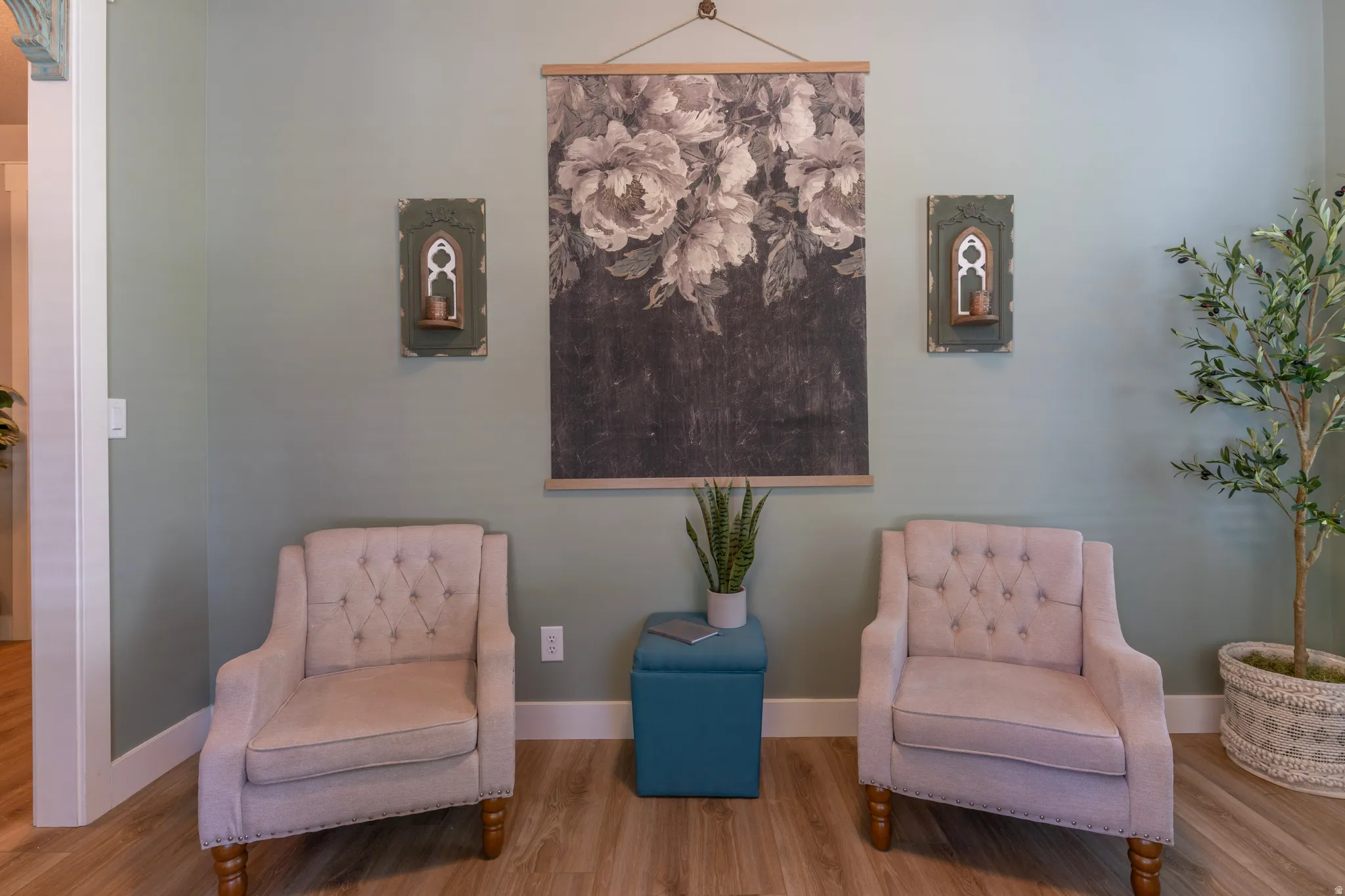 Light wood-finish flooring complements soft green wall tones