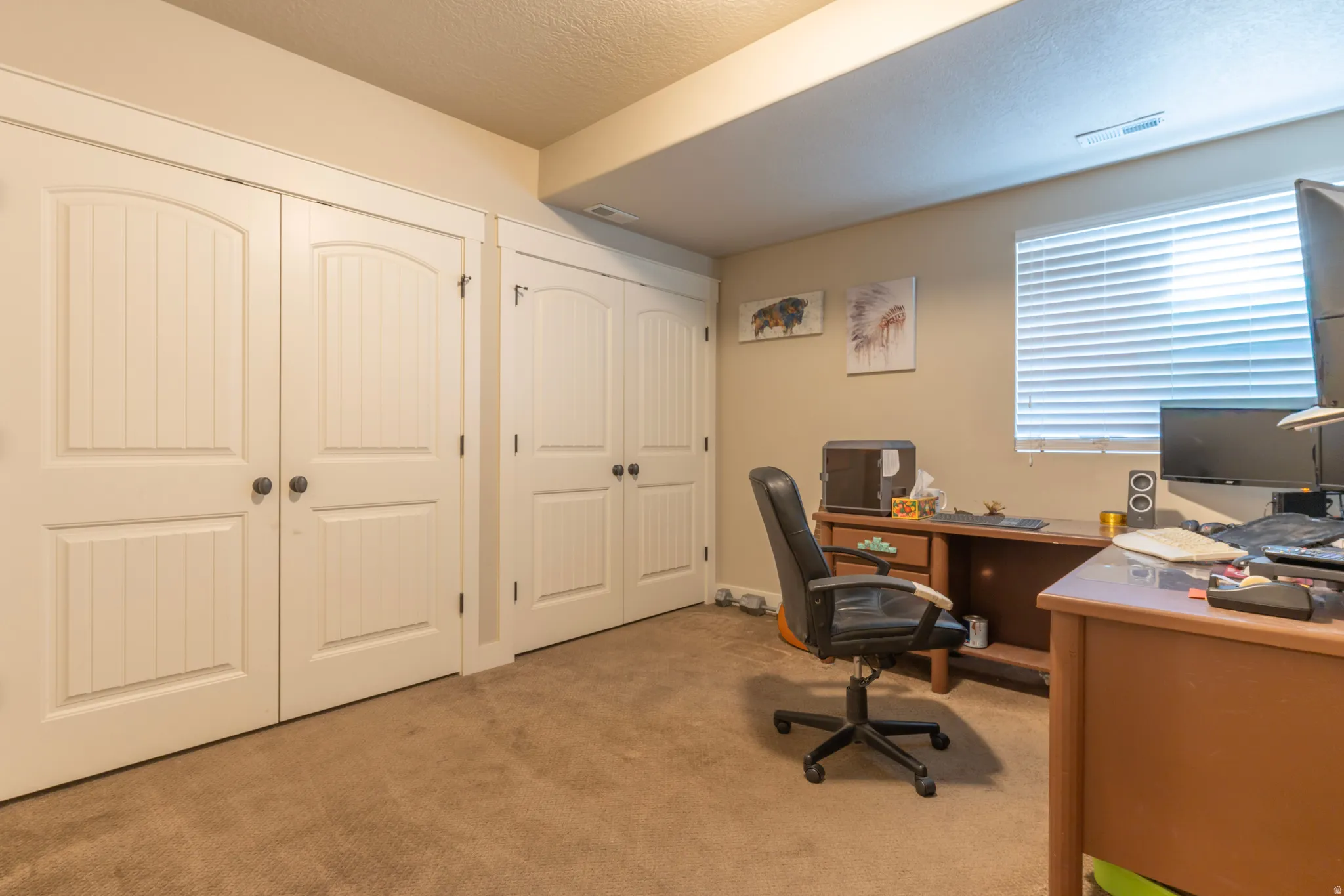 Bedroom featuring four white paneled doors with arch details, neutral tone walls, and carpet flooring