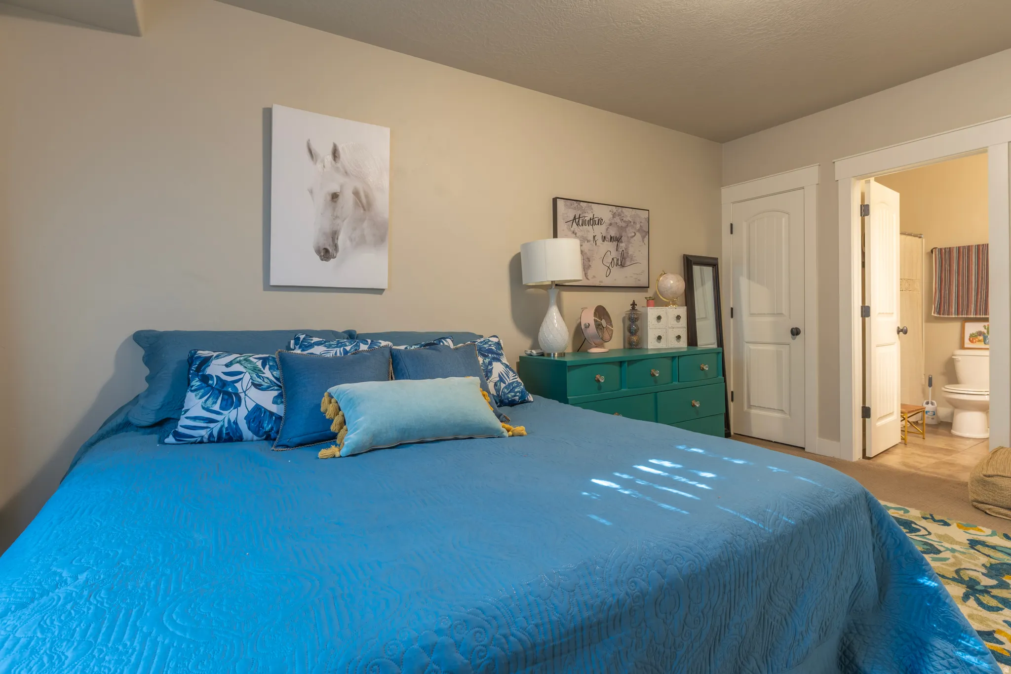 Room featuring neutral wall tones, a built-in closet with a paneled door, and an entryway to a full bathroom