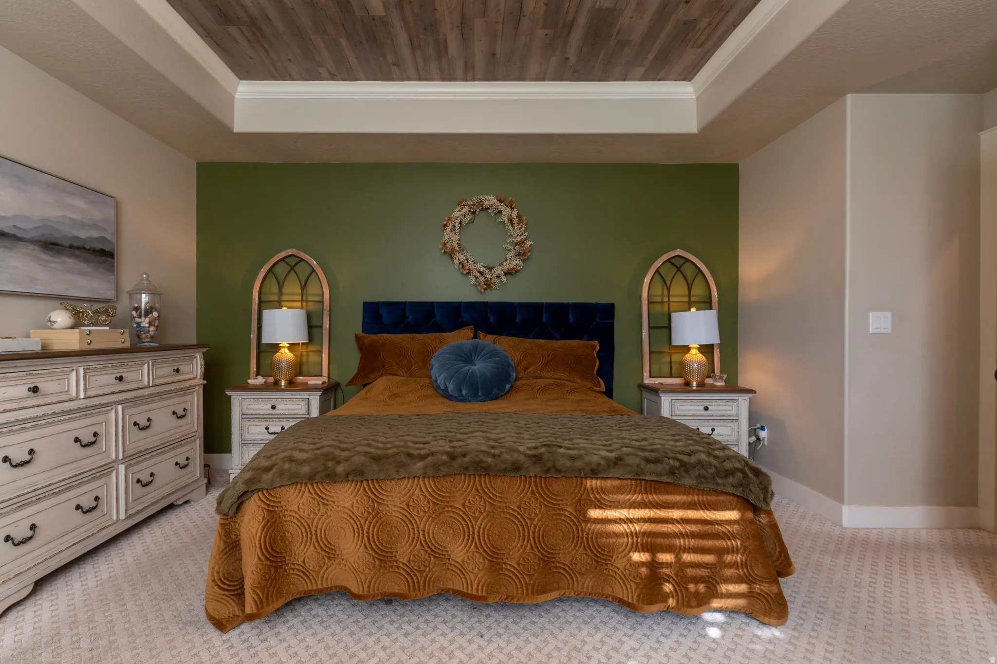 Recessed tray ceiling featuring wood-finish paneling, a distinctive accent wall, wall-to-wall patterned carpeting, and white baseboards