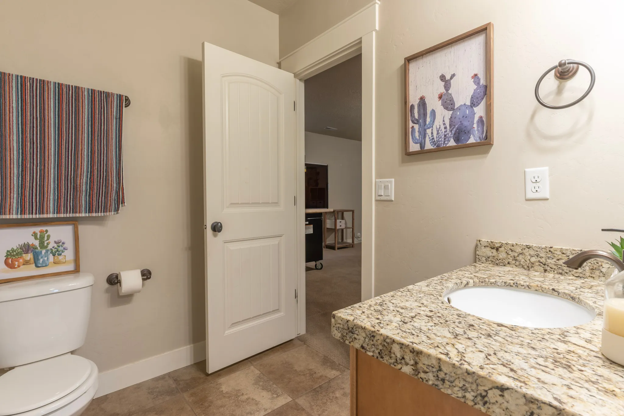 Bathroom featuring a granite-finish countertop, under-mount sink, and a bronze-finish faucet