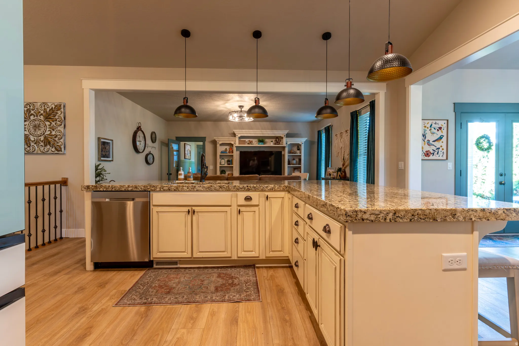 Spacious kitchen island featuring a granite-style countertop, cream-colored cabinetry, and a stainless steel dishwasher