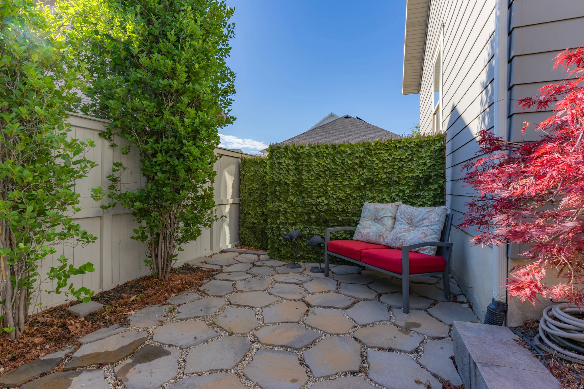Hexagonal paver patio featuring a surrounding privacy fence