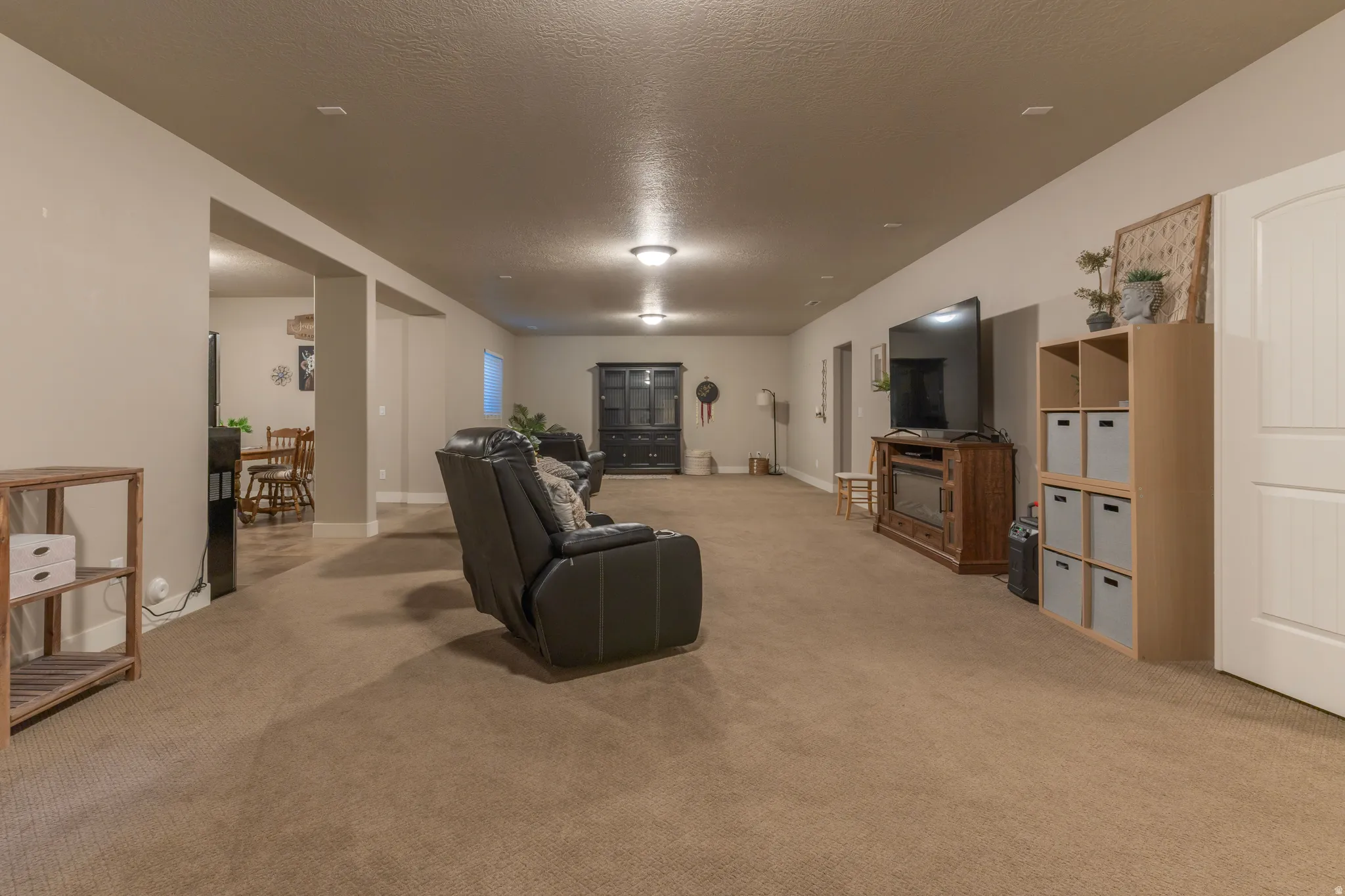 Expansive recreational room featuring soft carpeting, recessed lighting, and a neutral color palette