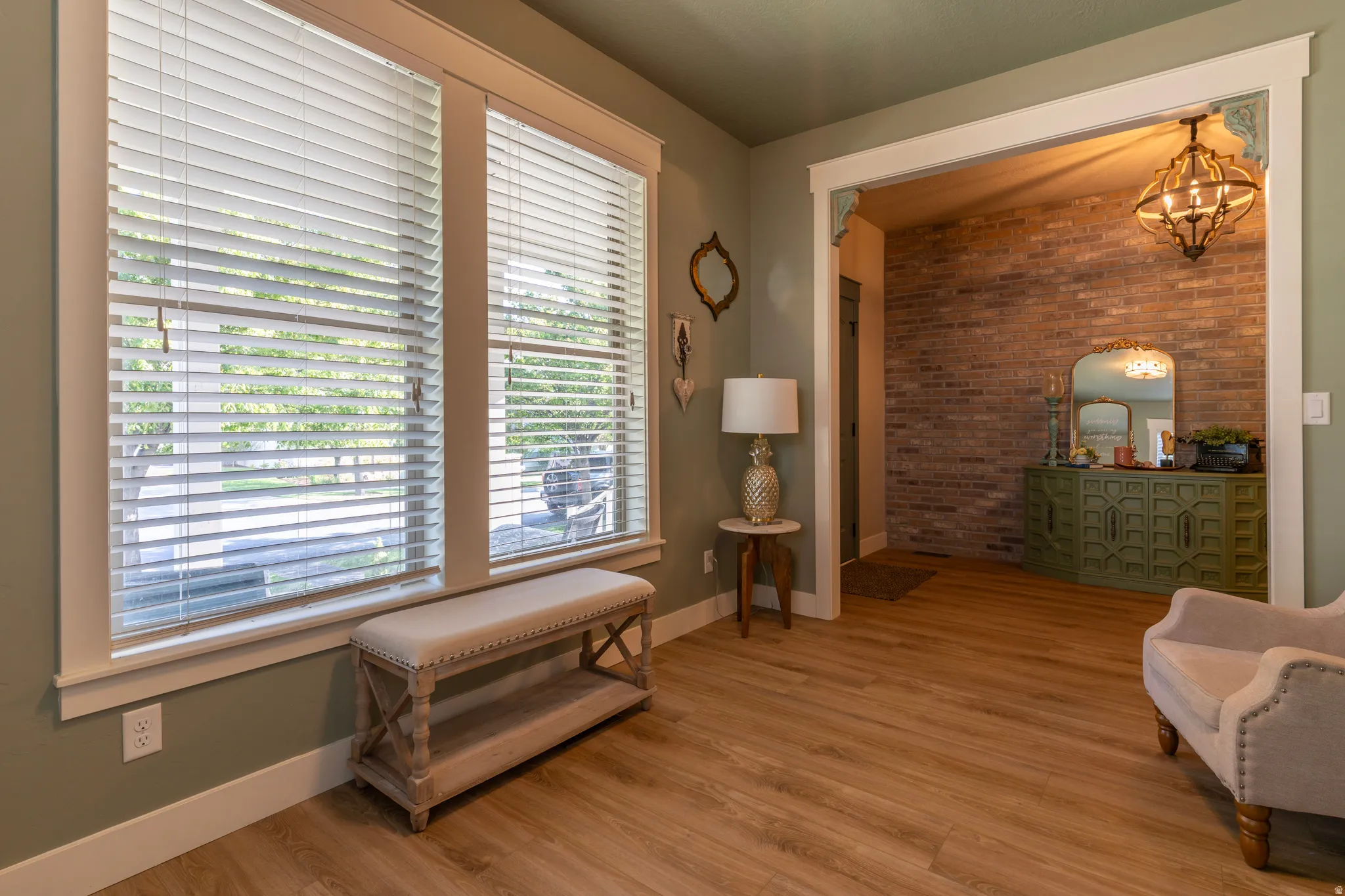 Open archway with brick accent wall and ornate chandelier