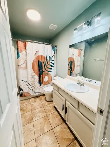 Bathroom vanity featuring an integrated sink, laminate countertop, and white cabinetry with matte black hardware