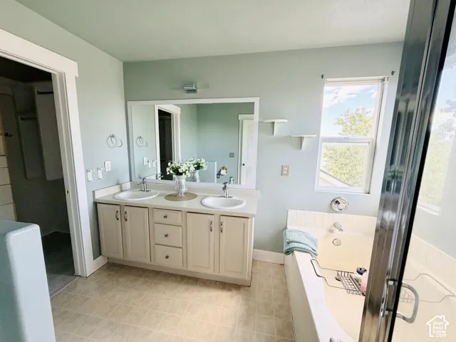 Double vanity with undermount sinks and light-toned cabinetry, set against a pale blue wall