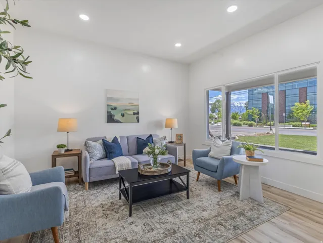 Bright living space featuring expansive windows, recessed lighting, wood-finish flooring, and white baseboards