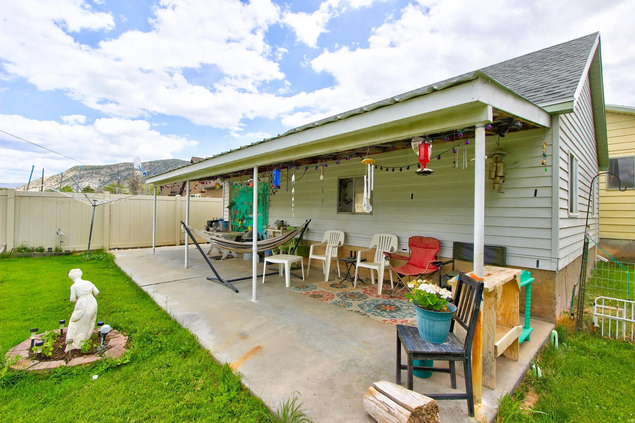 Covered concrete patio with white siding exterior