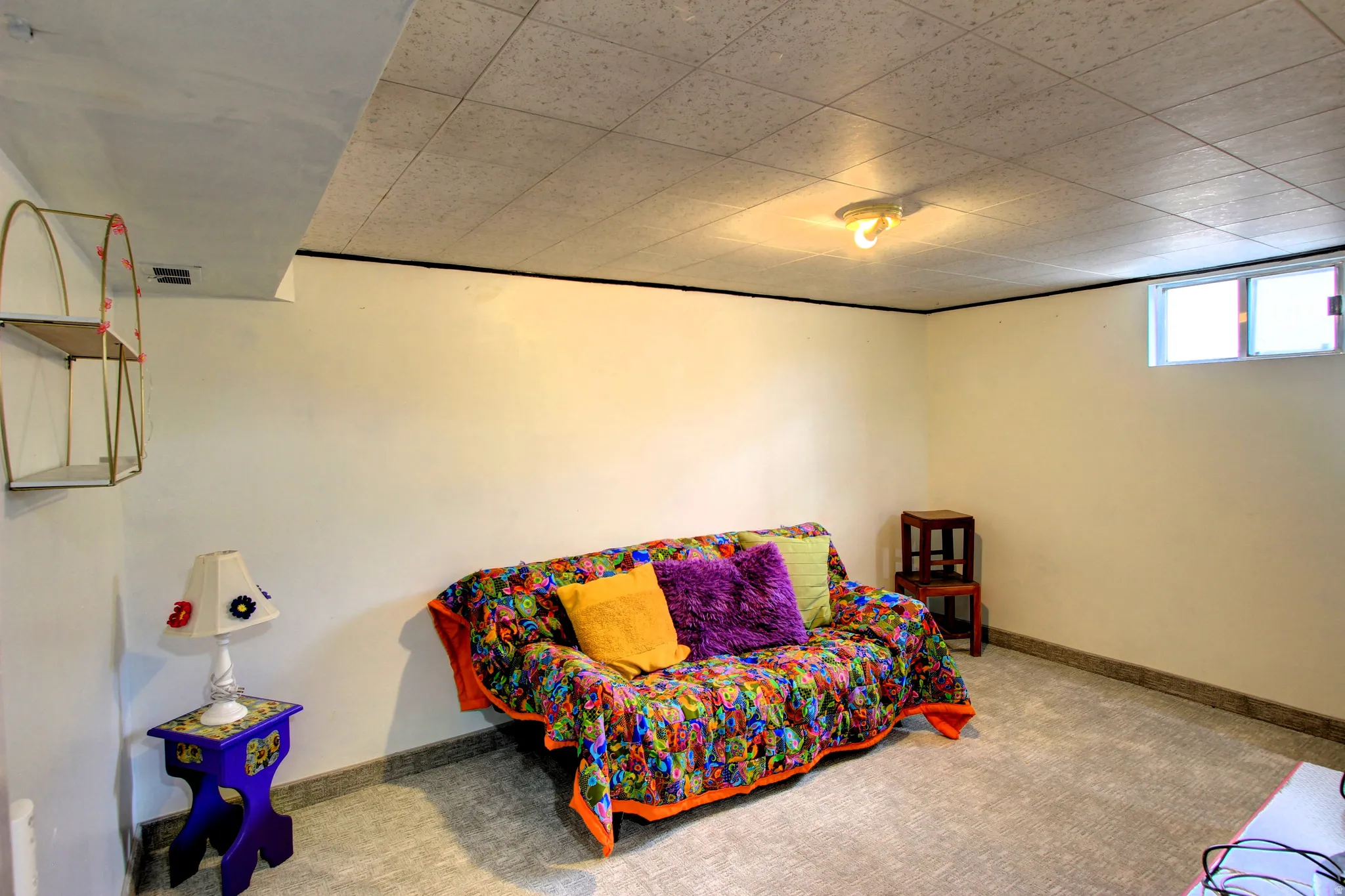 Versatile finished room featuring a drop ceiling, wall-to-wall carpeting, and a single window