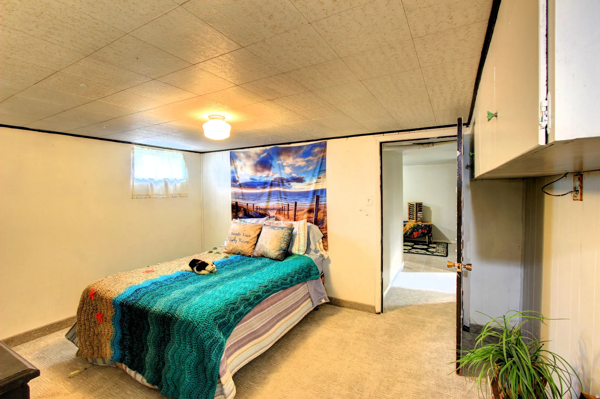 Carpeted room with a drop ceiling and white walls