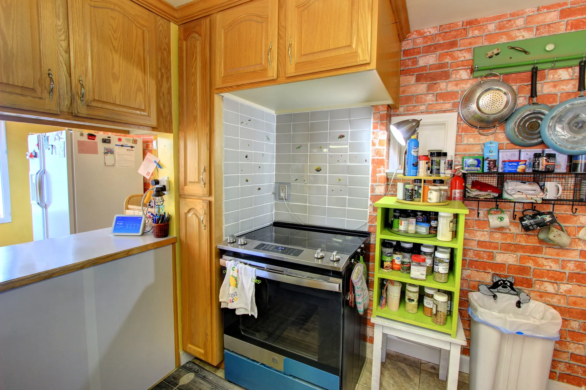 Functional kitchen featuring a stainless steel range with a gray tile backsplash