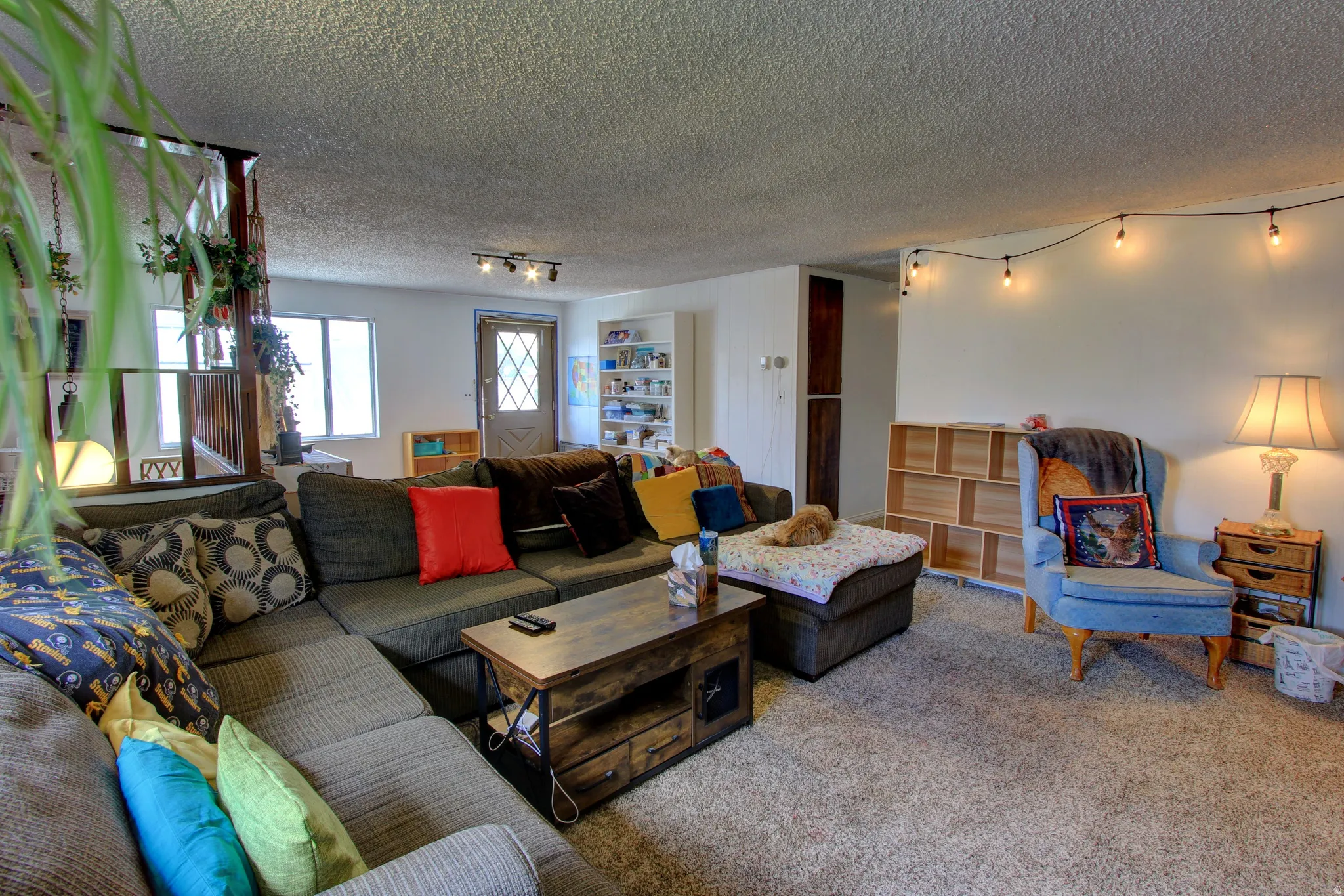 Living area featuring light-colored walls and textured ceiling