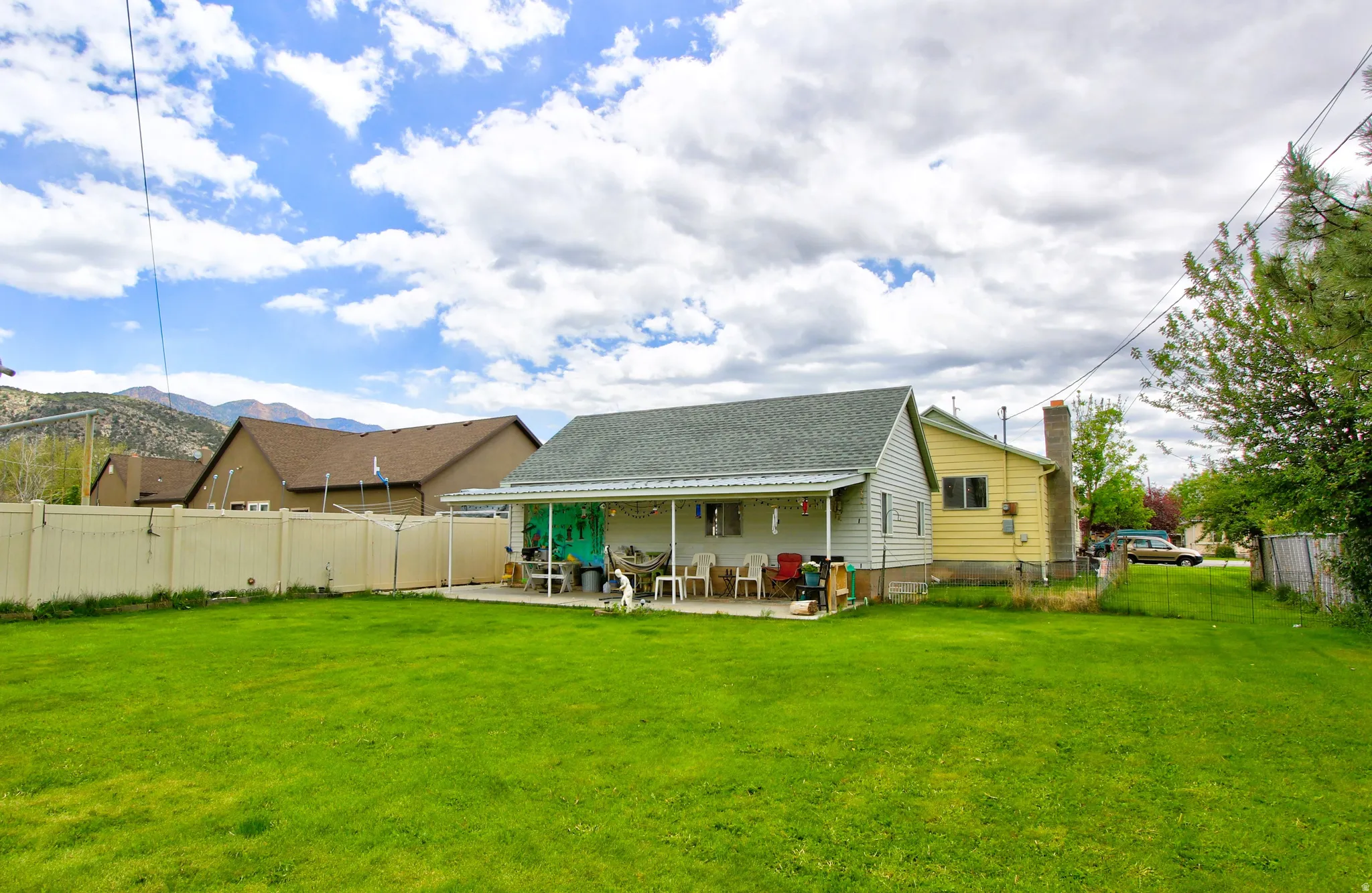 Expansive green lawn with a covered patio area