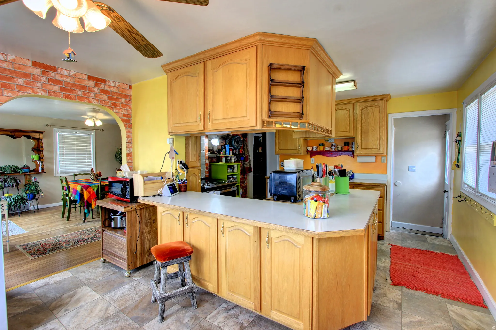 Kitchen featuring wood-finish cabinetry, light-toned countertops, and tile flooring