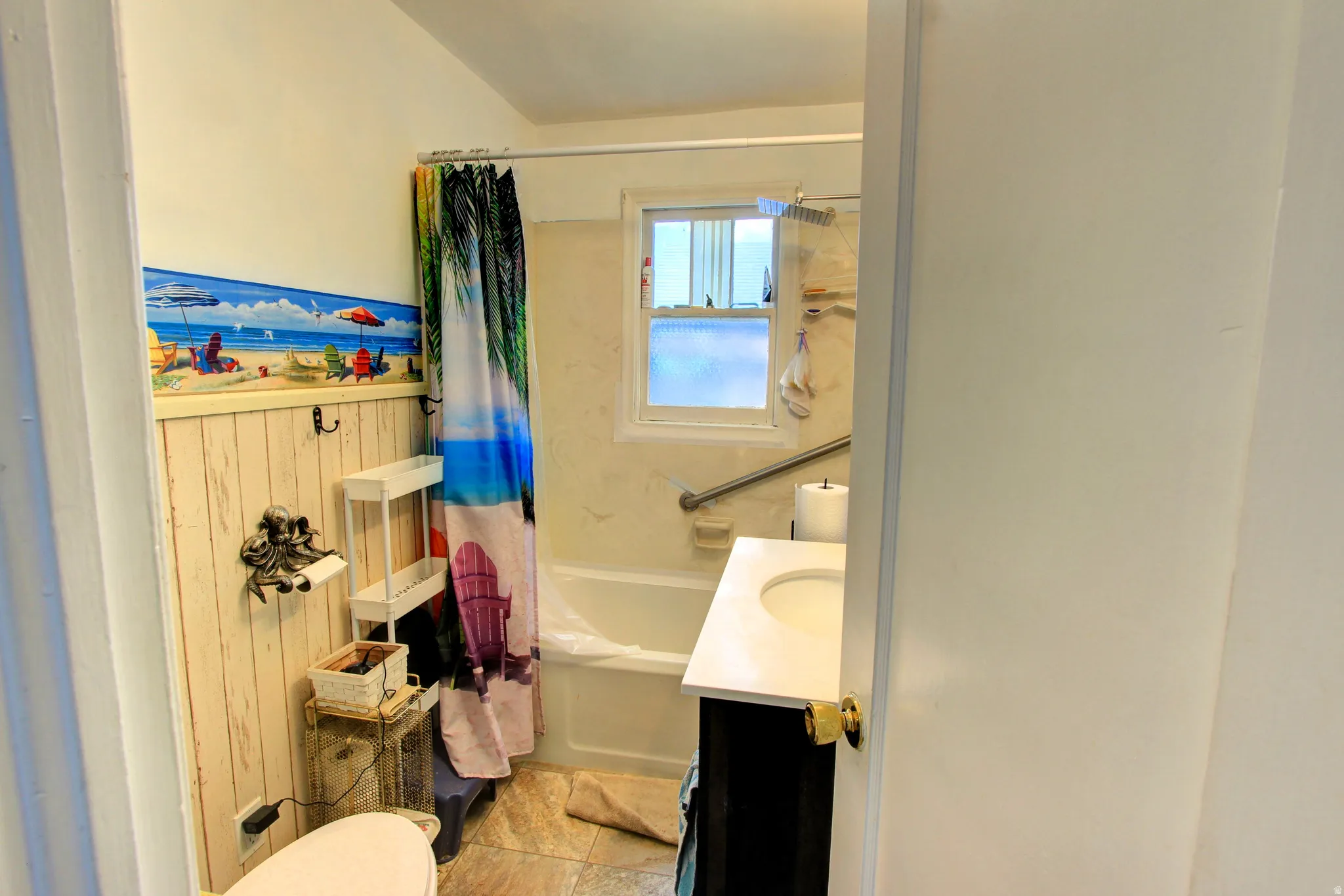 Full bathroom featuring a white bathtub, white vanity with integrated sink, and wood-finish wainscoting
