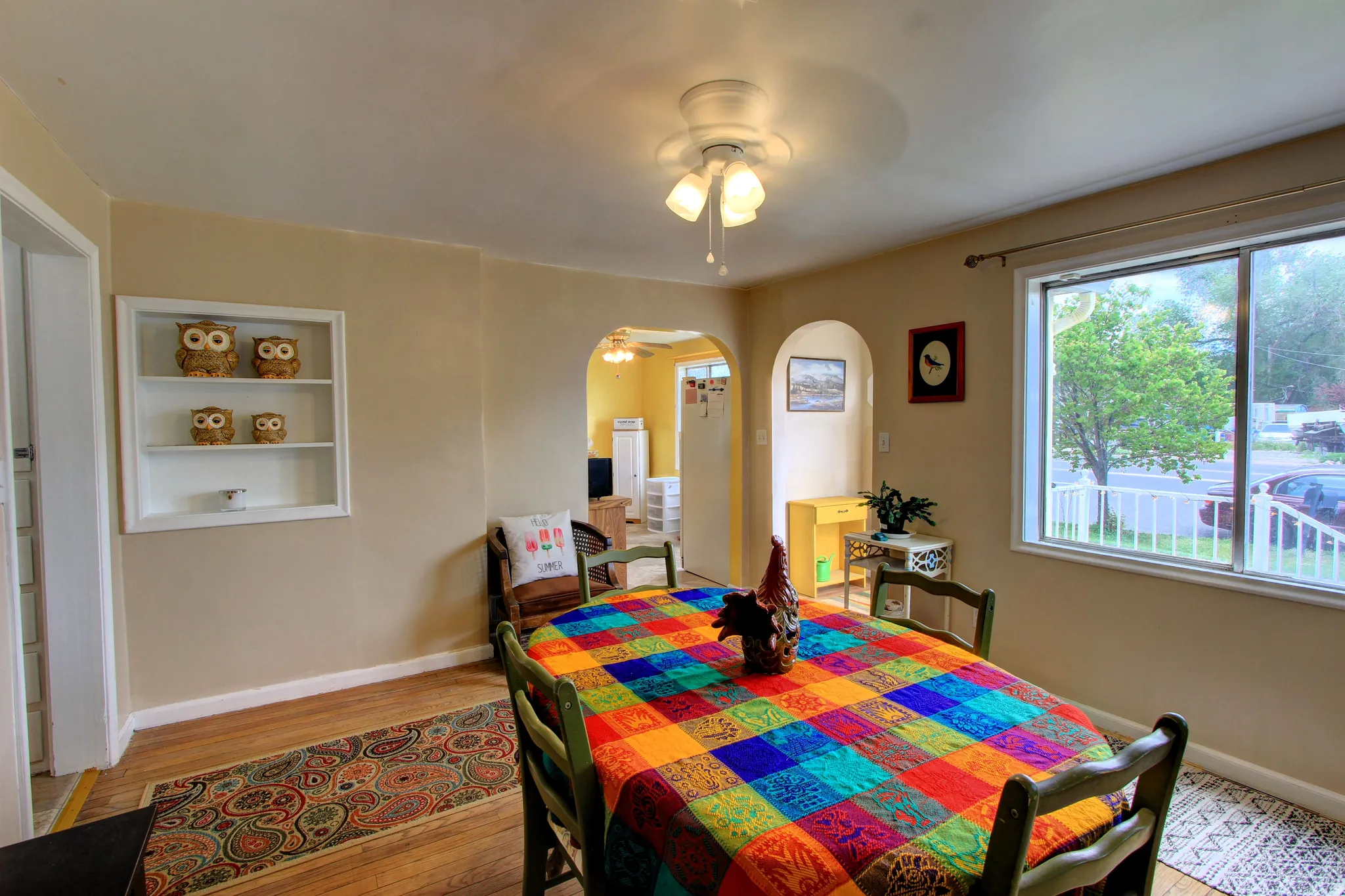 Dining area featuring wood-finish flooring, a ceiling fan with light fixture, and a built-in wall shelf
