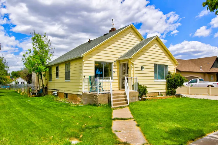 Yellow siding exterior with a pitched roof and a front porch
