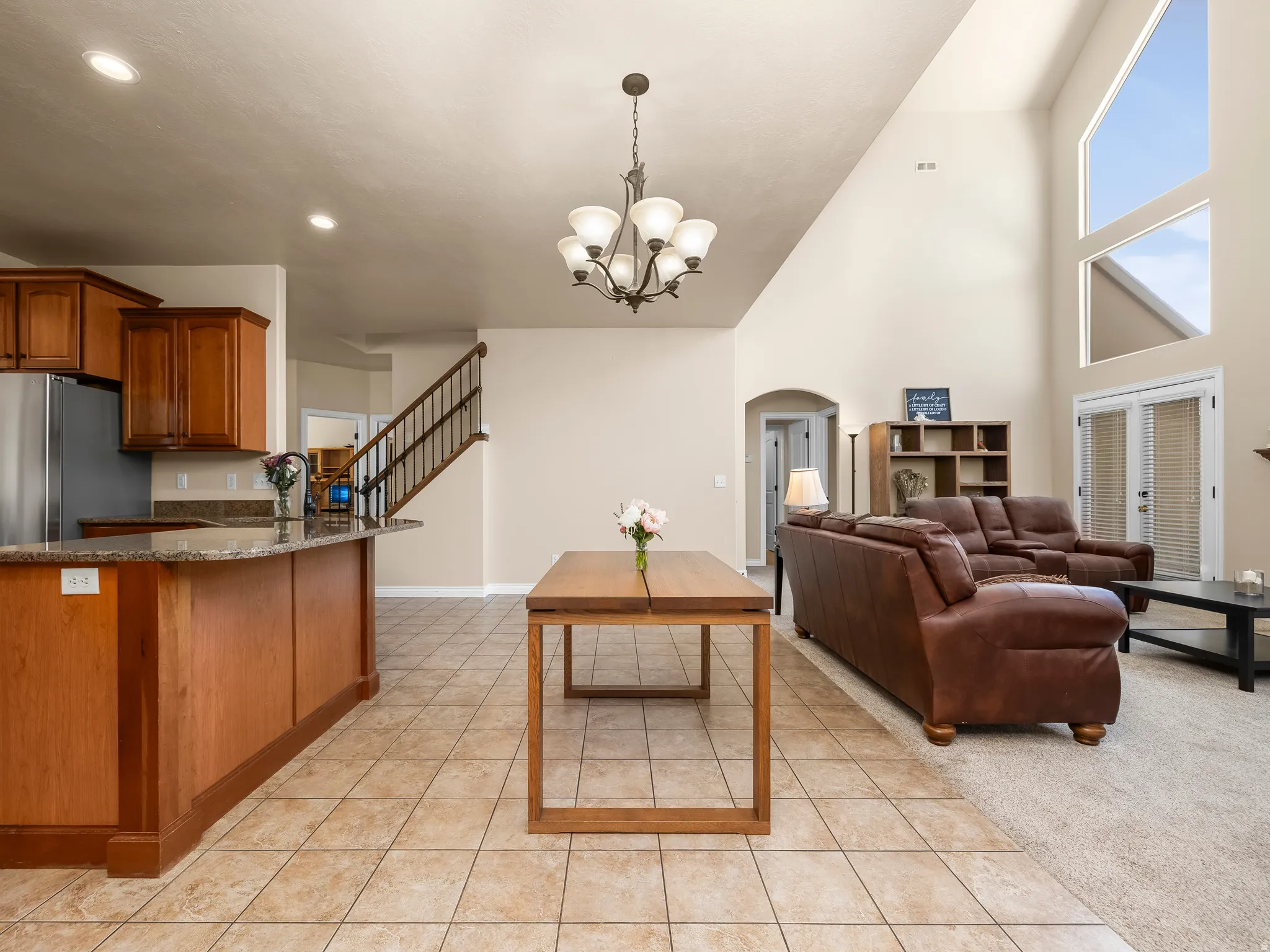 Open-concept living space featuring a two-story vaulted ceiling and expansive windows