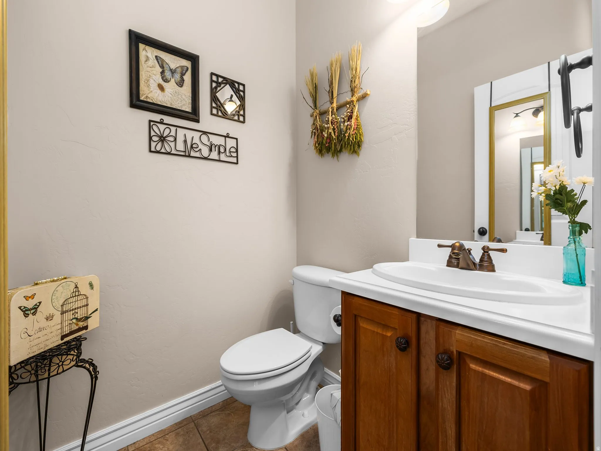 Powder room featuring a single vanity with wood-finish cabinetry, a white countertop, and an oval sink