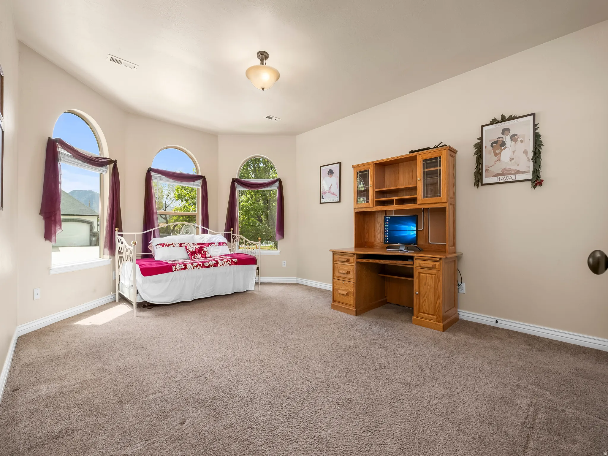Room featuring three arched windows, recessed lighting, and neutral-toned carpeting