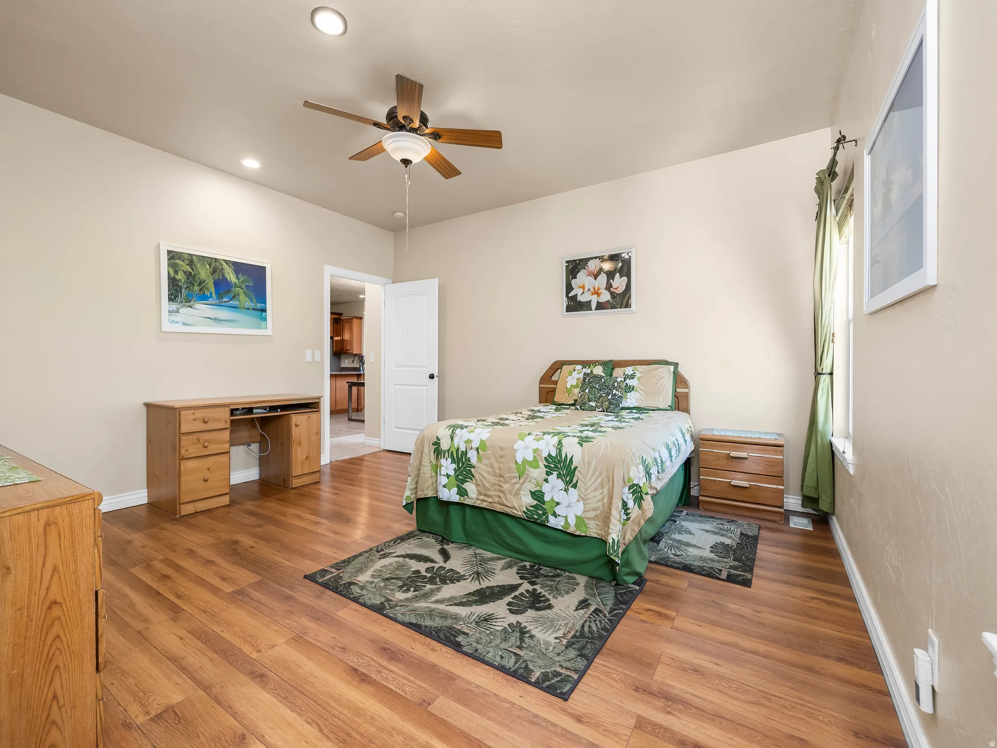 Spacious room featuring wood-finish flooring, recessed lighting, and a ceiling fan