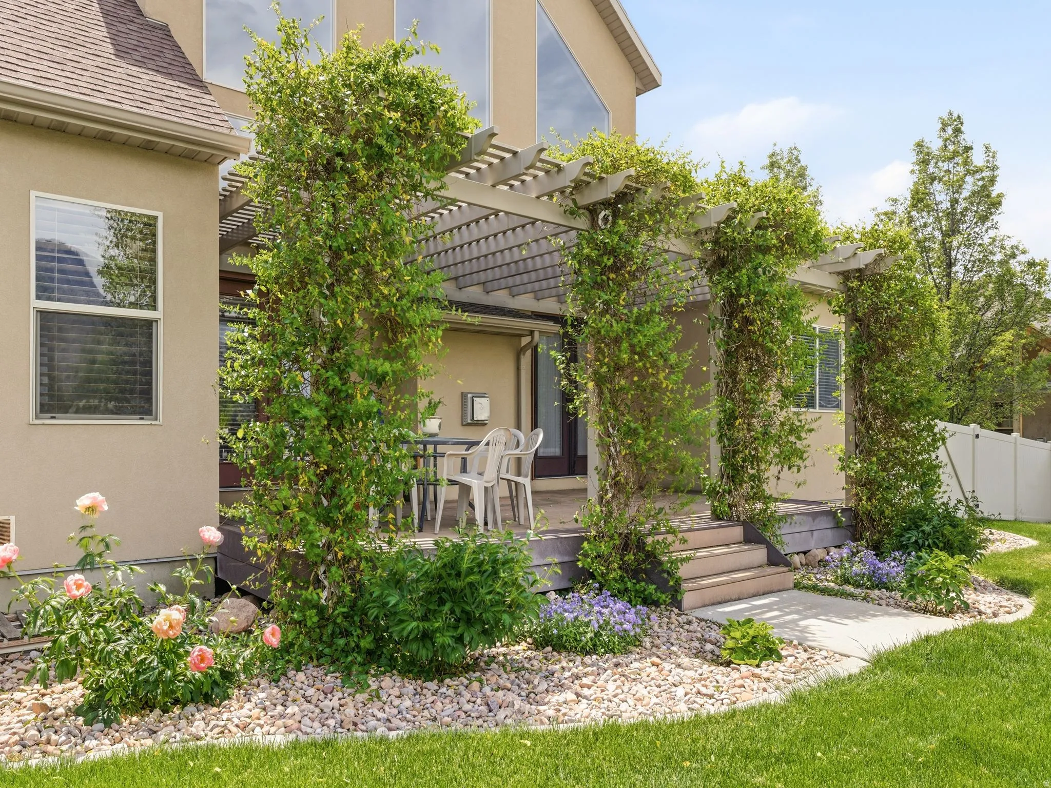 Expansive pergola-covered deck with climbing vines, offering an outdoor living area
