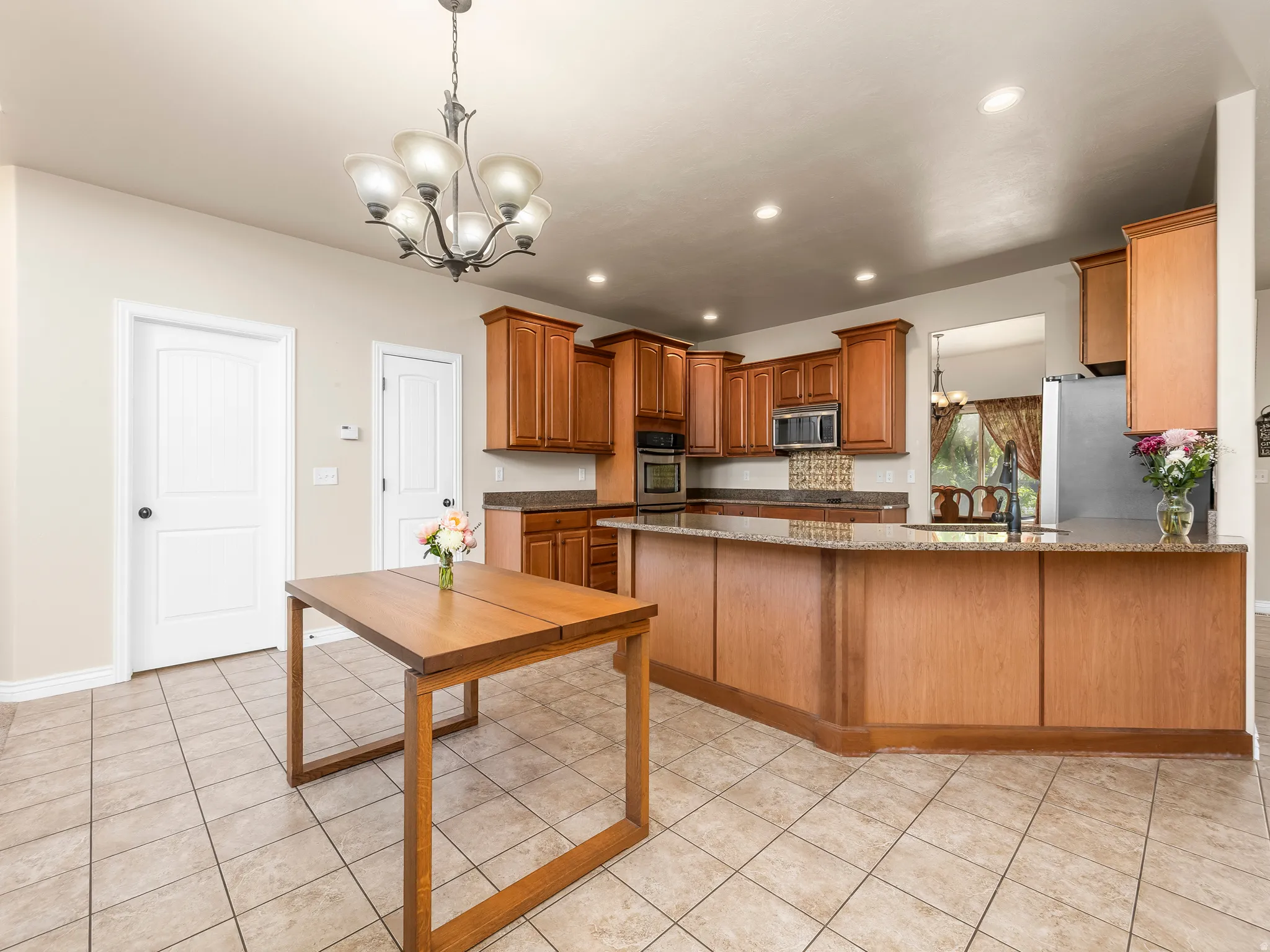 Kitchen featuring extensive wood cabinetry, stone countertops, integrated stainless steel appliances, and a tiled backsplash