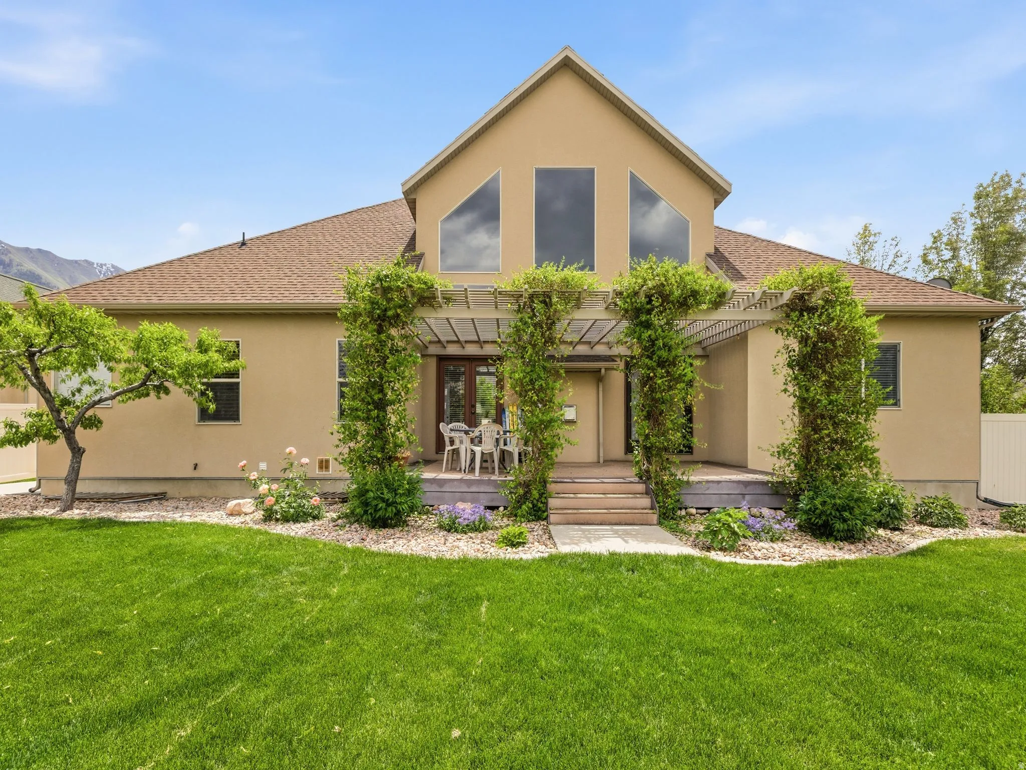 Expansive backyard featuring a large green lawn and landscaped garden beds