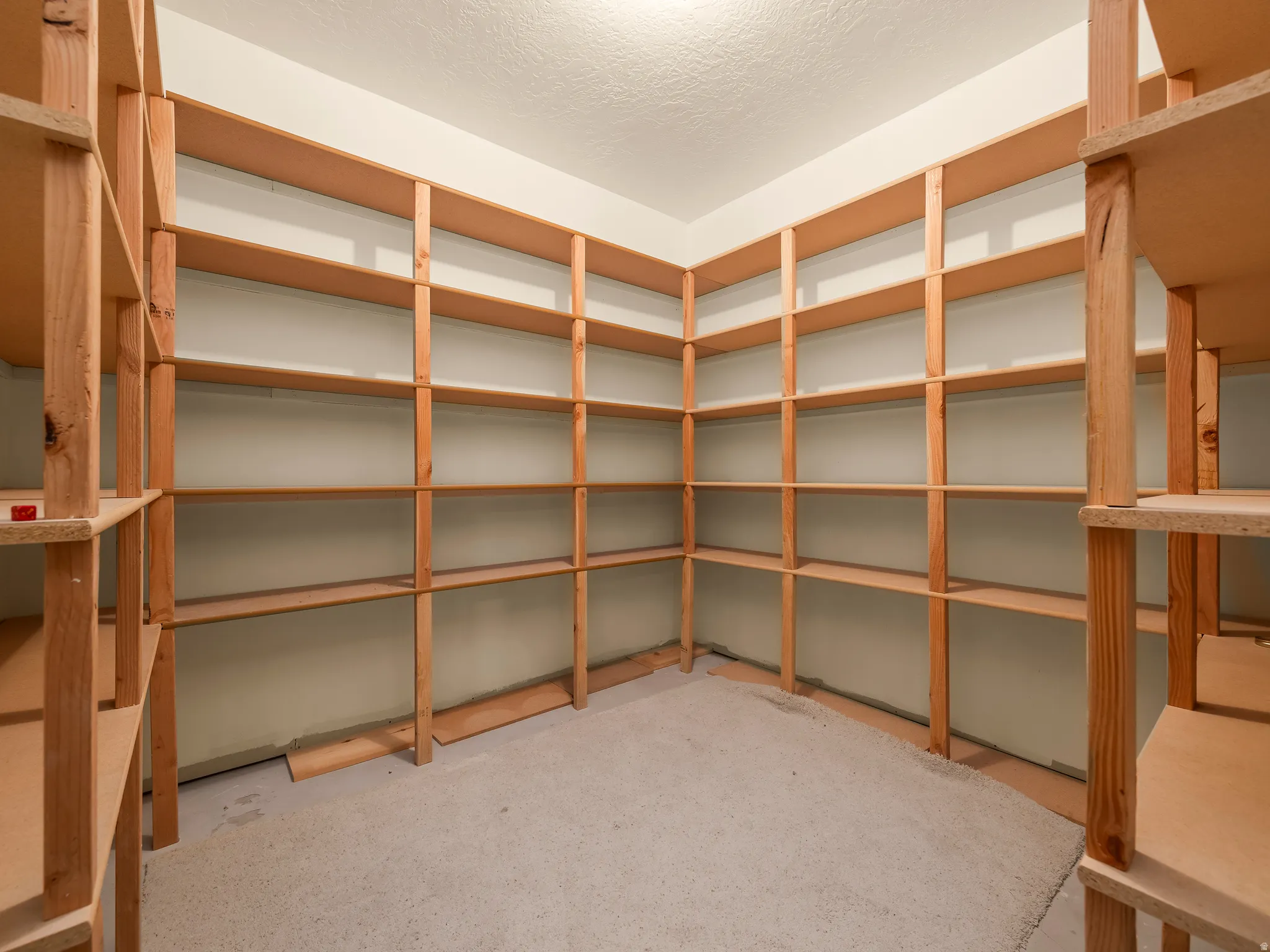 Built-in wood shelving system featuring extensive storage capacity, light-toned wood construction, and a corner configuration