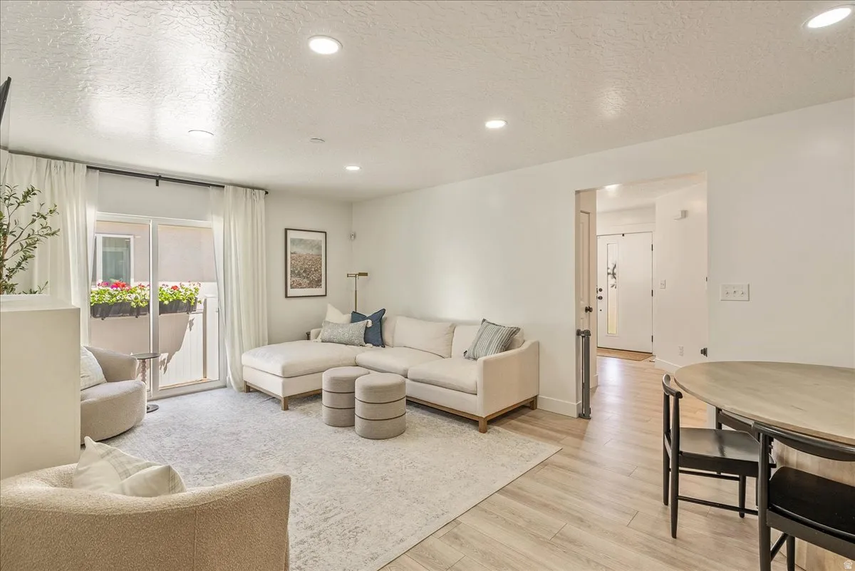 Open concept living area featuring light wood-finish flooring, recessed lighting, and a sliding glass door