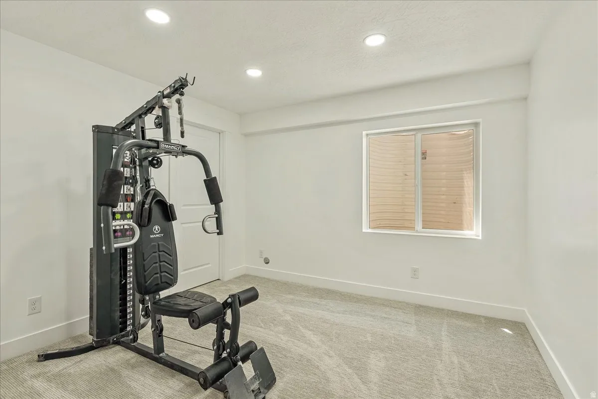 Spacious room featuring light-colored carpet, white walls, and recessed lighting