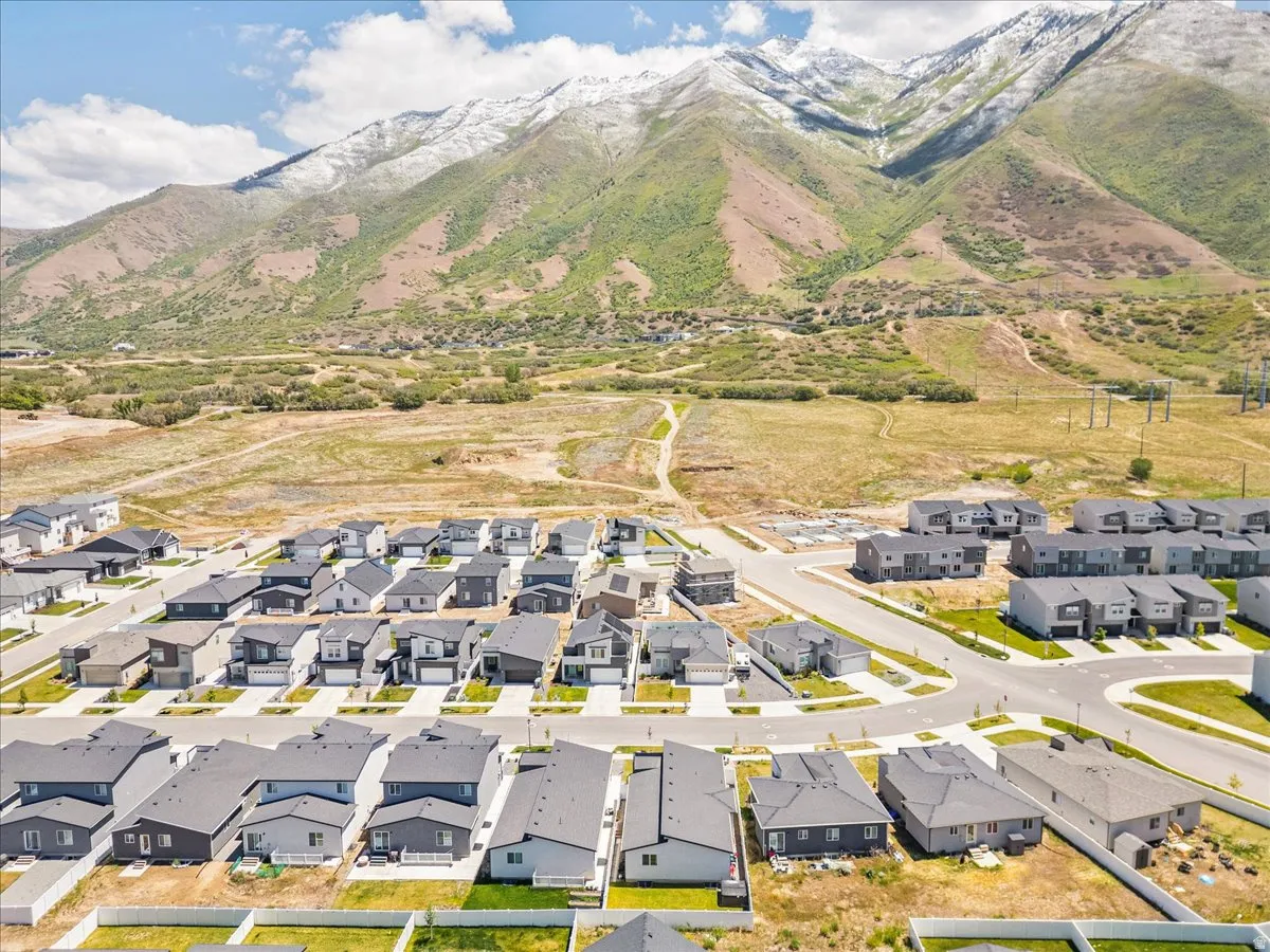 New construction residential development featuring a mountain backdrop with snow-capped peaks